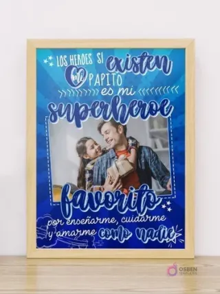 Cuadro Día del Padre editable con marco de madera claro, diseño azul vibrante y mensaje 'Mi Papito es mi superhéroe favorito por enseñarme, cuidarme y amarme como nadie' con foto de padre e hija sonriendo y compartiendo un regalo.