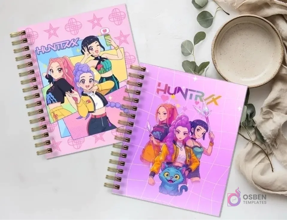 Dos agendas espiraladas 'HUNTRIX' con diseños de personajes femeninos de anime y un gato azul, sobre una superficie de mármol con una planta y un plato vacío.