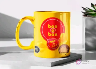 Taza de cerámica color amarillo brillante sublimada con el diseño del bombón Bon o Bon, en un mockup sobre una base gris clara.