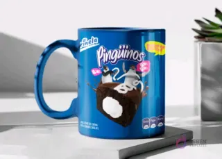 Taza de cerámica color azul brillante sublimada con el diseño de los pastelitos Pingüinos de Marinela y sus etiquetas de advertencia, en un mockup.