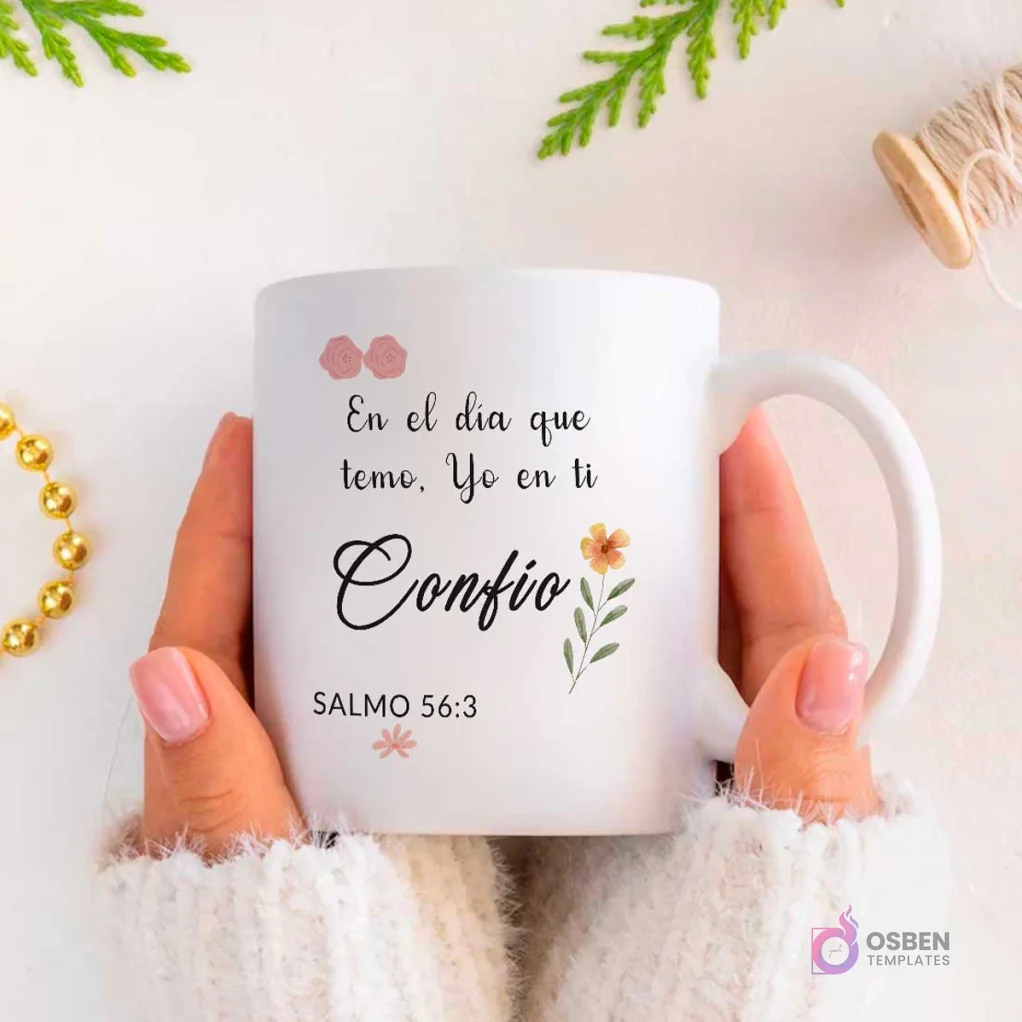 Manos sosteniendo taza blanca de sublimación con versículo Salmo 56:3 'En el día que temo, Yo en ti Confío' y detalles florales en rosa y verde.