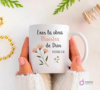 Taza blanca sublimada con el versículo bíblico Efesios 2:10 'Eres la obra Maestra de Dios' y un delicado diseño de flores rosadas y hojas verdes.