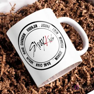 Taza blanca con el logo de Stray Kids en el centro de un círculo negro, rodeado por los nombres de los ocho miembros del grupo: Bang Chan, Lee Know, Changbin, Hyunjin, Han, Felix, Seungmin, I.N.