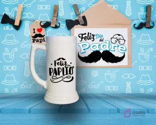 Shoperos blanco con diseño de sublimación 'Feliz Papito' en negro con detalles de bigote y adornos, sobre fondo azul de mesa de madera.