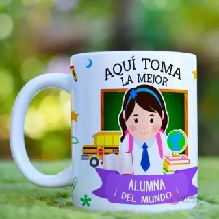 Taza de cerámica blanca con diseño sublimado de una alumna feliz con mochila y útiles escolares, rodeada de un autobús y libros, con la frase 'Aquí Toma La Mejor Alumna Del Mundo!' sobre un fondo de pizarrón.