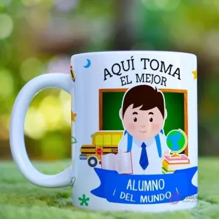 Taza de cerámica blanca con diseño sublimado de un alumno feliz con mochila y útiles escolares, rodeado de un autobús y libros, con la frase 'Aquí Toma El Mejor Alumno Del Mundo!' sobre un fondo de pizarrón.