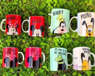 Ocho tazas sublimadas con personajes Disney (Minnie, Mickey, Goofy, Pluto) sobre césped verde, mostrando diseños frontal y trasero.