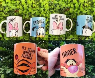 Ocho tazas sublimadas con personajes Disney (Daisy, Donald, Tigger) sobre césped verde, mostrando diseños frontal y trasero.