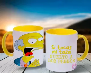 Un par de tazas de Los Simpsons, blancas con el interior amarillo, con el Sr. Burns asustado en una y la frase 'Si tocas mi taza suelto a LOS PERROS' en la otra, frente a un cielo azul y montañas.