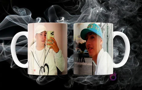 Dos tazas blancas sublimadas con diseños de los artistas urbanos Pailita y Jairo Vera, en un fondo oscuro con humo.