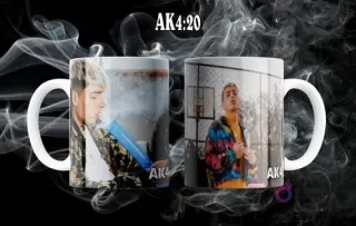 Dos tazas blancas sublimadas con diferentes poses dinámicas del artista urbano AK4:20, sobre un fondo oscuro y humo.