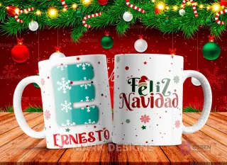 Taza sublimada con la letra E mayúscula en turquesa adornada con copos de nieve, junto al nombre 'ERNESTO' y al reverso 'Feliz Navidad' con estrellas y copos de nieve.