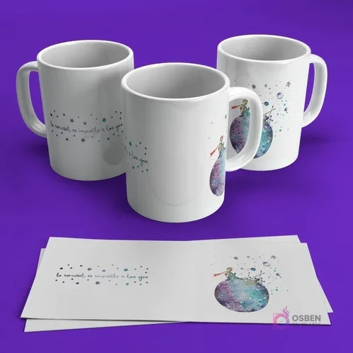 Tres tazas blancas para sublimar con El Principito sobre un planeta salpicado de colores estelares y la famosa frase 'Lo esencial es invisible a los ojos'. Fondo violeta.