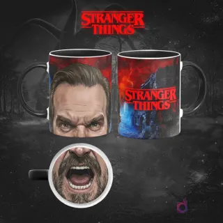 Taza sublimada de Stranger Things con el Jefe Hopper, expresión de rabia y barba, reverso con el logo y escenas del Upside Down, sobre fondo oscuro.