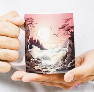 Mug con diseño 3D de costa rocosa con olas rompientes y un atardecer rosado, aves volando sobre el mar, sostenido por manos.