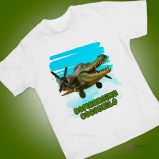 Polera blanca con estampado de cocodrilo animado pilotando un avión de guerra, sobre un cielo azul.