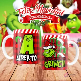Taza de sublimación del Grinch temática de Navidad con la inicial 'A' y el nombre de ejemplo 'ALBERTO', sobre fondo a cuadros rojo y blanco, junto a otra taza del Grinch con diseño navideño 'Esta Taza Pertenece al Grinch'. El fondo general muestra personajes del Grinch en Navidad.