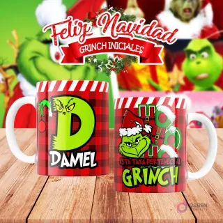Taza de sublimación del Grinch temática de Navidad con la inicial 'D' y el nombre de ejemplo 'DAMEL', sobre fondo a cuadros rojo y blanco, junto a otra taza del Grinch con diseño navideño 'Esta Taza Pertenece al Grinch'. El fondo general muestra personajes del Grinch en Navidad.