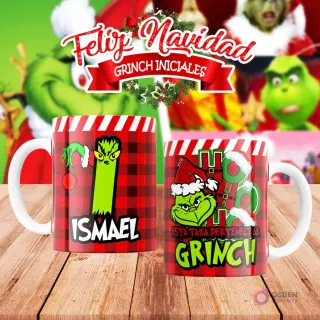 Taza de sublimación del Grinch temática de Navidad con la inicial 'I' y el nombre de ejemplo 'ISMAEL', sobre fondo a cuadros rojo y blanco, junto a otra taza del Grinch con diseño navideño 'Esta Taza Pertenece al Grinch'. El fondo general muestra personajes del Grinch en Navidad.