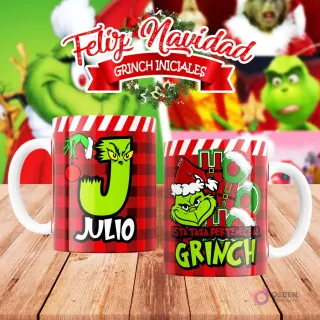 Taza de sublimación del Grinch temática de Navidad con la inicial 'J' y el nombre de ejemplo 'JULIO', sobre fondo a cuadros rojo y blanco, junto a otra taza del Grinch con diseño navideño 'Esta Taza Pertenece al Grinch'. El fondo general muestra personajes del Grinch en Navidad.