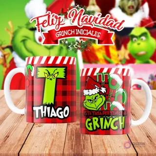 Taza de sublimación del Grinch temática de Navidad con la inicial 'T' y el nombre de ejemplo 'THIAGO', sobre fondo a cuadros rojo y blanco, junto a otra taza del Grinch con diseño navideño 'Esta Taza Pertenece al Grinch'. El fondo general muestra personajes del Grinch en Navidad.