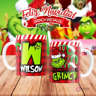 Taza de sublimación del Grinch temática de Navidad con la inicial 'W' y el nombre de ejemplo 'WILSON', sobre fondo a cuadros rojo y blanco, junto a otra taza del Grinch con diseño navideño 'Esta Taza Pertenece al Grinch'. El fondo general muestra personajes del Grinch en Navidad.