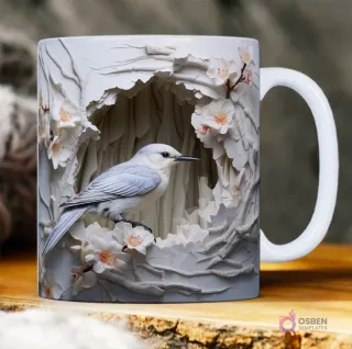 Taza sublimada con ave azul claro 3D en un nido rocoso con relieve, rodeada de flores blancas y rosadas.