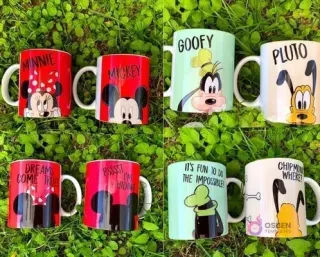 Cuatro tazas sublimadas con personajes Disney (Minnie, Mickey, Goofy, Pluto) sobre césped verde, mostrando anverso y reverso