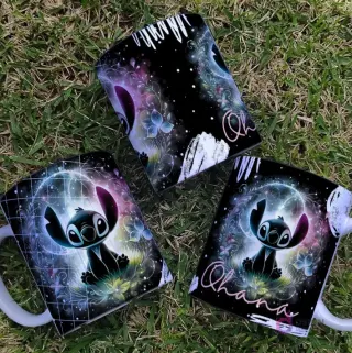 Conjunto de tazas con Stitch Black sentado entre flores y mariposas luminosas, con un fondo de galaxia sutil y brillante.