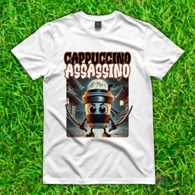 Camiseta blanca con diseño de 'Cappuccino Assassino', una taza de café ninja con espadas frente a un templo japonés y una luna llena.