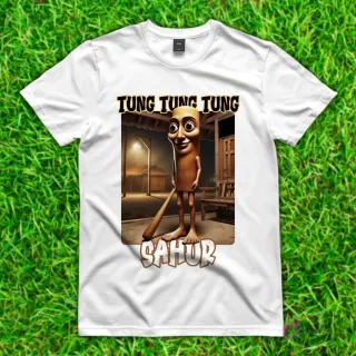 Camiseta blanca con diseño de 'Tung Tung Tung Sahur', una figura alargada y sonriente con ojos grandes, sosteniendo un bate en una habitación rústica.
