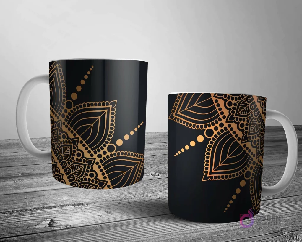 Dos tazas blancas con un lujoso diseño de mandala en oro metálico sobre un fondo negro, ofreciendo un contraste sofisticado y elegante.