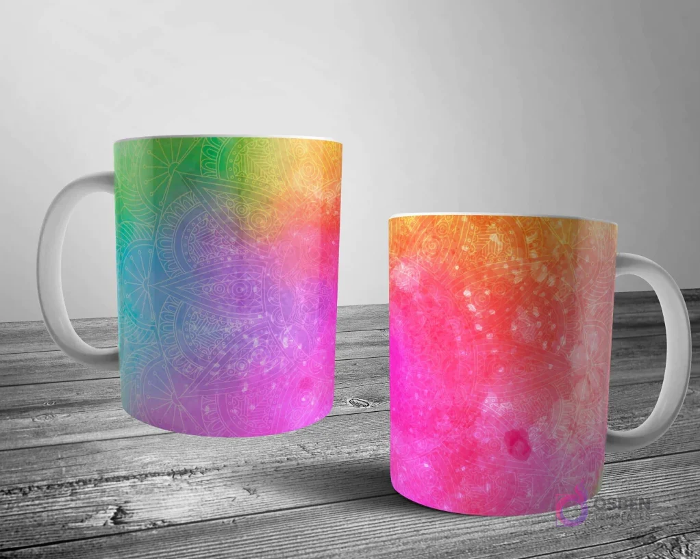 Dos tazas blancas con un patrón de mandala sutil sobre un fondo de arcoíris vibrante y degradado, simulando una explosión de pintura.