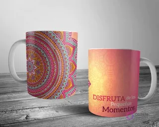 Dos tazas blancas con un diseño de mandala detallado. Una con un gran mandala rosa-teal-naranja y la otra con un patrón más sutil y la frase 'DISFRUTA de los Pequeños Momentos' en tonos cálidos.