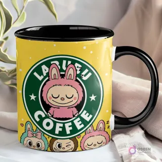 Taza amarilla con interior y asa negros, presentando el logo 'LABUBU COFFEE' con un Labubu rosa de ojos cerrados y otros Labubu en la base.