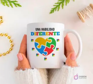 Manos sujetando una taza blanca con la frase 'UNA HABILIDAD DIFERENTE' y un corazón de puzzle rodeado de pequeñas piezas.