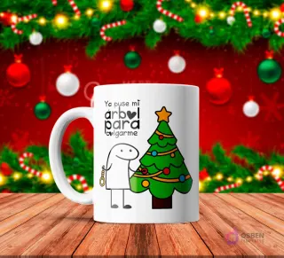 Taza de sublimación blanca con Flork junto a un árbol de Navidad decorado, sosteniendo una soga, texto 'Ya puse mi árbol para colgarme' con fondo rojo festivo.