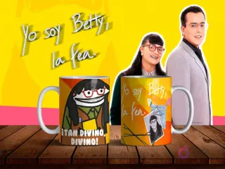 Dos tazas de sublimación con diseños de Flork Betty la Fea, una con la frase '¡TAN DIVINO, DIVINO!' y otra con Betty Pinzón original, sobre mesa de madera con fondo amarillo y personajes de la telenovela.