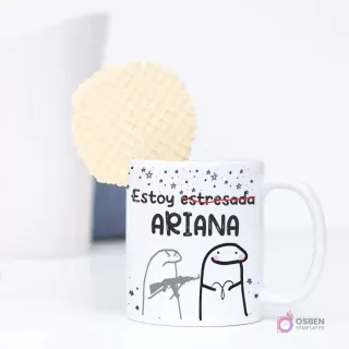Taza de sublimación con diseño de Flork de Aries y la frase 'Estoy estresada ARIANA', mostrando un Flork con un rifle de juguete y otro con expresión de estrés. Una galleta waffle se asoma por detrás.