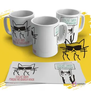 Mockup de taza blanca con diseño de gato negro con gafas de sol y dedo corazón levantado, con la frase 'Llegué tarde porque no quería venir' en rojo. Vista de tres tazas con la plantilla extendida al frente sobre fondo amarillo.