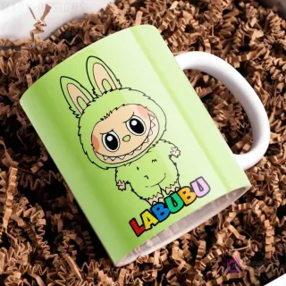 Taza de cerámica verde lima con diseño del personaje Labubu de traje peludo verde, con el nombre Labubu en letras coloridas, sobre papel picado marrón.