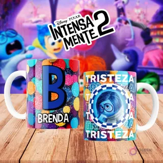 Mugs temáticos de Intensamente 2. Taza frontal con la letra 'B' en azul sobre confeti multicolor y nombre 'BRENDA'. Taza trasera con el personaje Tristeza de Disney Pixar y la palabra 'TRISTEZA'. Fondo borroso de la película.