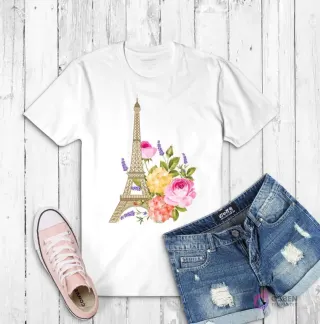 Polera blanca con una ilustración de la Torre Eiffel adornada con un ramo de flores rosadas, amarillas y lilas