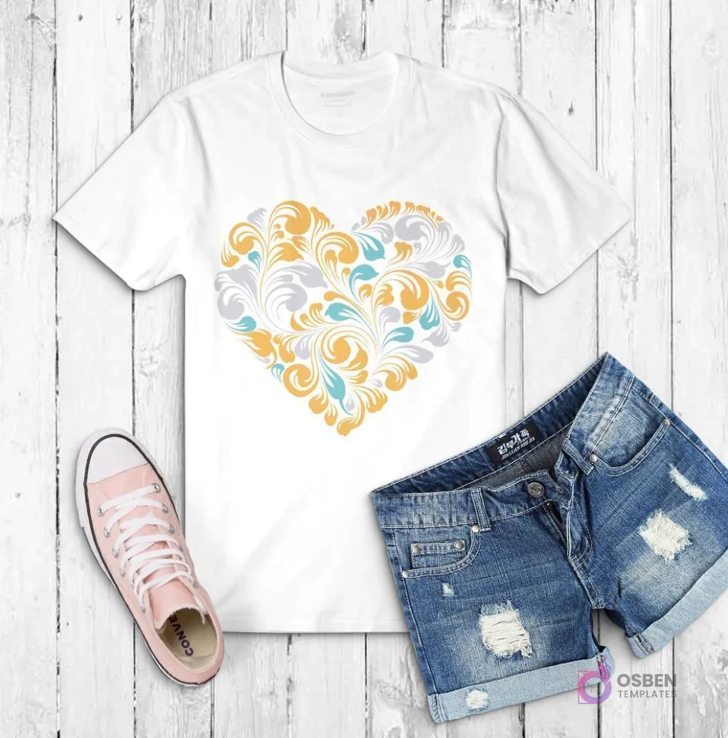 Polera blanca con un corazón ornamentado compuesto por remolinos y filigranas en tonos dorados, azules y grises