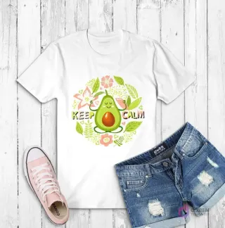 Polera blanca con ilustración de un aguacate sonriente haciendo yoga y la frase 'KEEP CALM', rodeado de flores y hojas
