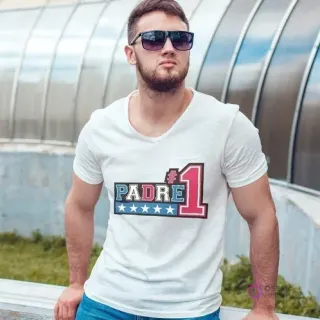 Hombre con gafas de sol usando una polera blanca con el diseño 'PADRE #1' en colores rojo, azul y blanco, perfecto para el super papá.