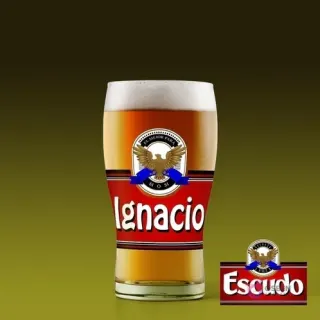 Vaso de cerveza tipo shopero con diseño personalizado 'Ignacio' estilo Cerveza Escudo, fondo verde oscuro.