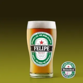 Vaso de cerveza con diseño personalizado 'Felipe Para el mejor Papá del Mundo Mundial' estilo Heineken, sobre fondo verde oscuro.
