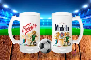 Dos tarros cerveceros blancos sublimados con diseños de cerveza Victoria y Cerveza Modelo Especial, ambos con el jaguar mascota del Mundial 2026, sobre fondo de estadio