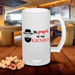 Jarra de cerveza esmerilada con diseño 'Mi papá es un GENIO!' con silueta de bigote, gafas y sombrero, sobre mesa de madera con cacahuetes, fondo de bar. Plantilla sublimación Padre Genio.